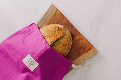 Meadow Magic reusable bread bag with a loaf of bread on a wooden cutting board