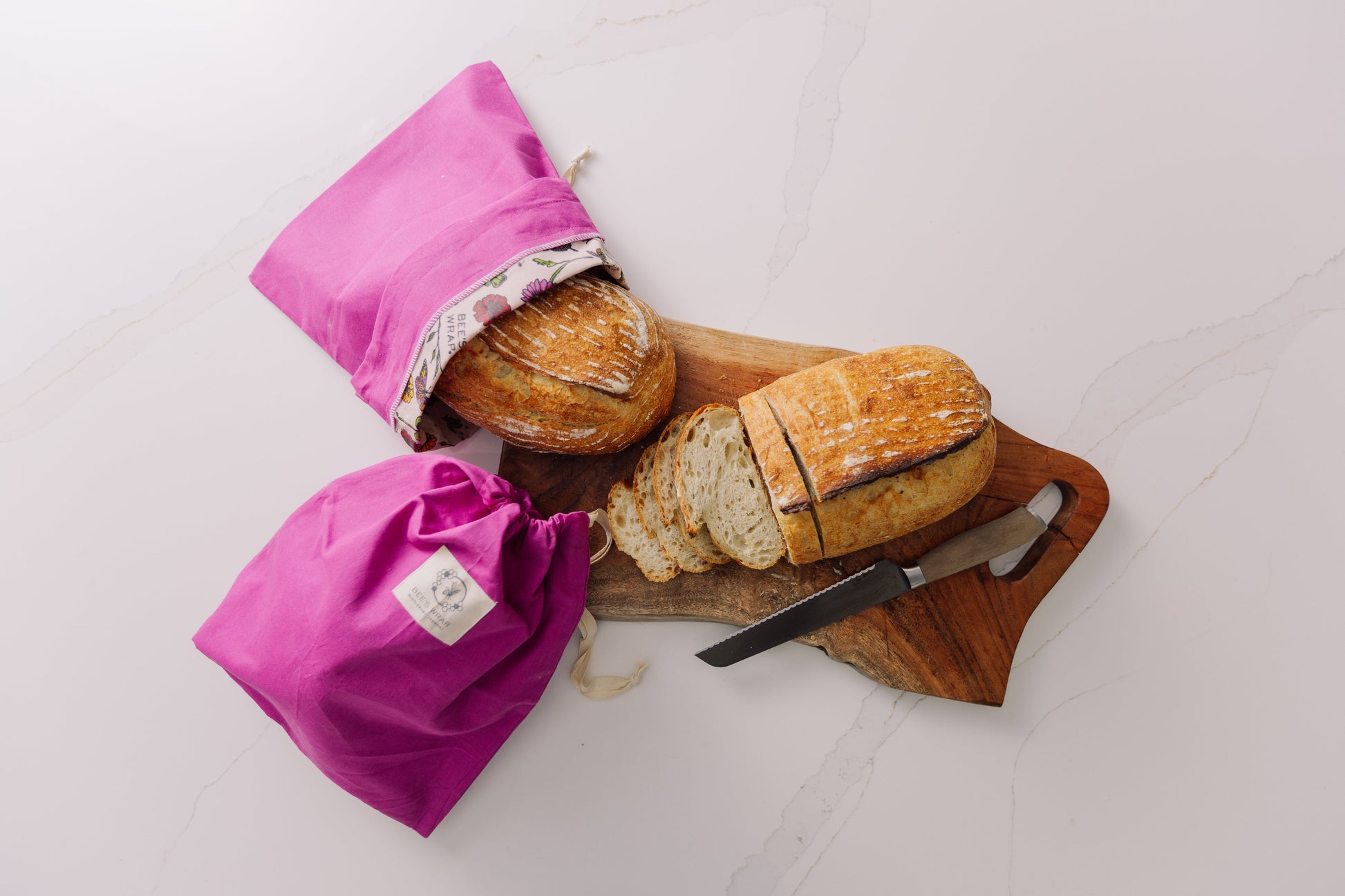 Bread in Meadow Magic Bread Bag  on a wooden cutting board with a knife on a white background